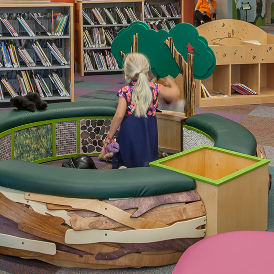 girl playing in a tot spot nest structure 